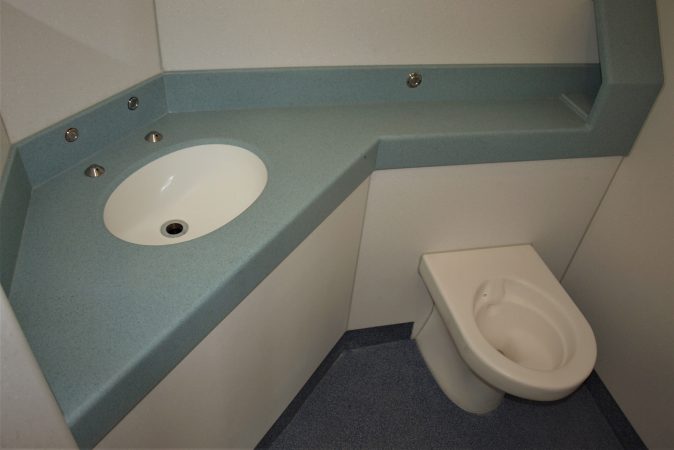 Pupil Referral Unit bathroom, moulded Corian surface with toilet roll space