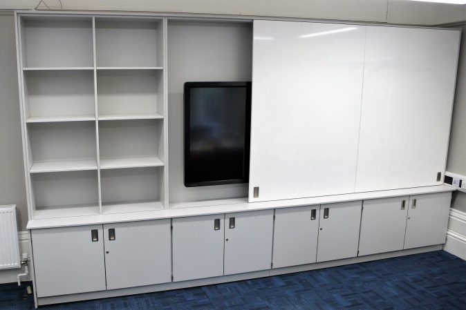 Teaching wall with screen, storage and sliding doors